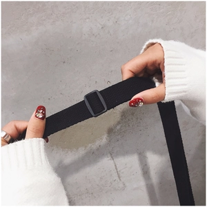 Detail of black nylon shoulder strap with adjustable buckle on plush cartoon bag
