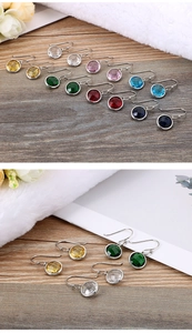 Macro shot of colorful round crystal titanium steel earrings with silver hooks