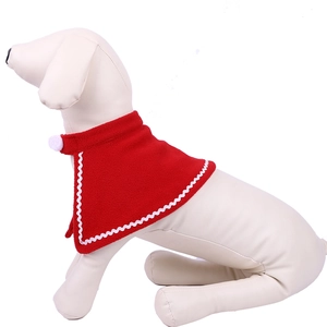 Detail of red Christmas pet cape with white wavy trim and soft pom-pom decoration