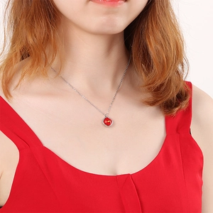 Minimalist silver necklace featuring a red irregular square pendant worn by a model