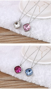 Detail of four colorful cushion cut crystal pendants on silver chains over a plush surface