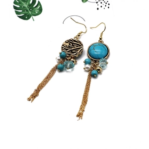 Detail view of Bohemian tassel earrings with blue turquoise beads and gold tree patterns