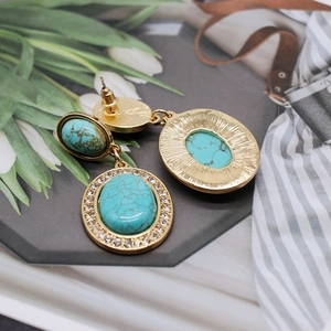 Detail of vintage turquoise drop earrings with gold metal base and sparkling rhinestones