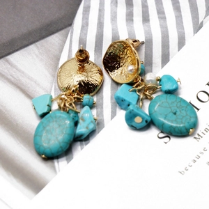 Detail of bohemian turquoise drop earrings with gold hammered metal and faux pearls