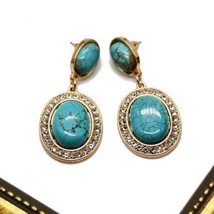 Detail of vintage turquoise drop earrings with gold frame and crystal rhinestone border