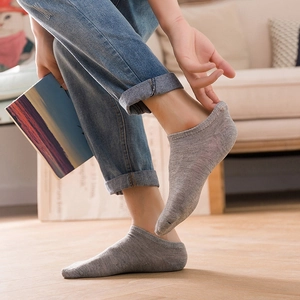 Comfortable grey low-cut invisible cotton socks worn by model in a cozy indoor setting