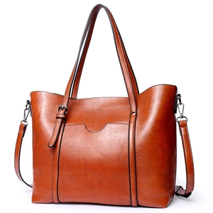 Grand sac fourre-tout vintage marron foncé avec poignée et bandoulière sur fond blanc
