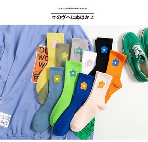 Detail of colorful knitted socks with cute 3D floral embroidery in multiple vibrant colors