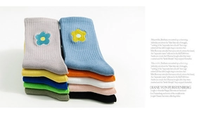 Detail showing embroidered floral patterns on rib-knit socks in various vibrant colors