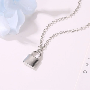 Macro shot of silver padlock pendant with sleek metal finish on a minimalist link chain