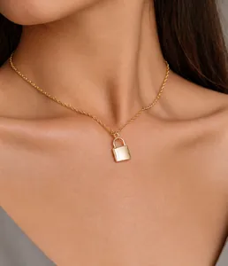 Detailed close-up of a minimalist champagne gold padlock pendant on a sleek collar chain