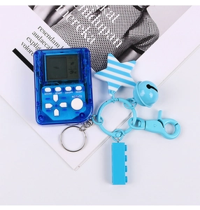 Primo piano di un portachiavi mini console Tetris blu con ciondoli a stella e mattoncini