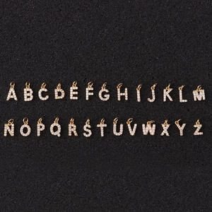 Golden A-Z initial necklaces with sparkling cubic zirconia on a textured background