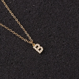 Macro shot of gold necklace featuring letter B pendant with sparkling zircon inlays