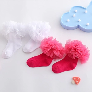 Detail von weißen und rosaroten Socken mit Spitzenbesatz für kleine Mädchen und Babys
