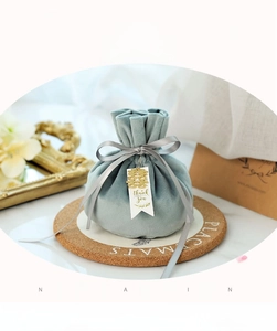 Detail of light blue velvet wedding candy bag with grey ribbon bow and gift card