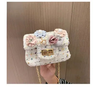 Dettaglio della mini borsa a tracolla in tweed con fiori in tessuto 3D, perle e catena d'oro