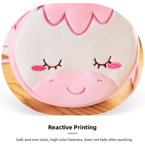 Detail of plush crossbody bag featuring embroidered facial expressions and soft pink texture
