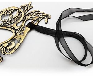 Detailed macro of gold embroidery pattern and sheer black ribbon on lace mask