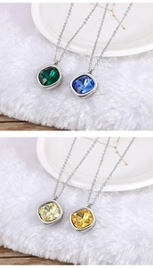 Détail de quatre colliers avec zircons carrés de 13mm sur un fond en peluche blanche douce