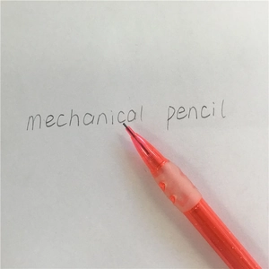 Detailed view of the orange mechanical pencil tip with soft rubber grip on white paper