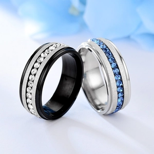 Detail of titanium steel rings with white and blue rhinestone inlay for couples