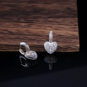 Elegant heart-shaped silver earrings with sparkling zircon stones in a macro view