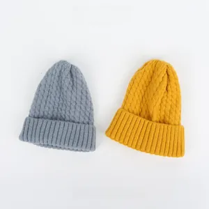 Detailansicht der grauen und gelben Strickmützen mit klassischem Zopfmuster-Design