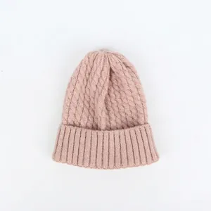 Nahaufnahme der rosa Strickmütze mit Zopfmuster, breitem Umschlag und warmer Textur