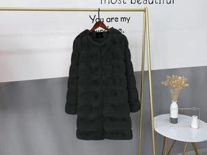 Close-up of thick dark grey faux fur coat featuring horizontal striped texture on hanger