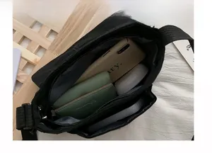 Detail view of the black canvas crossbody bag interior with multiple storage pockets