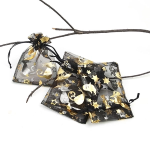 Detail of black gauze Halloween gift bag with gold star, moon and cat patterns