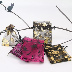 Detail of Halloween drawstring mesh gift bags with gold skull, pumpkin, and bat patterns