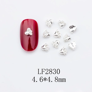 Macro view of silver alloy flower nail charms with white micro beads and dimensions