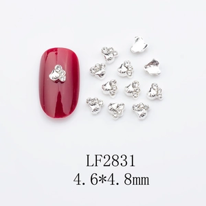 Silver paw print nail charm with white rhinestones on red nail, size 4.6x4.8mm