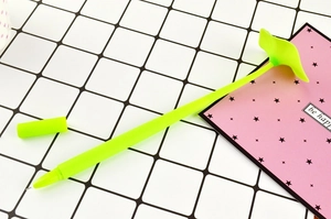 Macro detail of leaf-shaped creative gel pen with green silicone body on grid mat