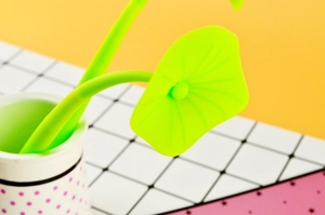 Close-up of green silicone clover leaf pen set in a white polka dot holder