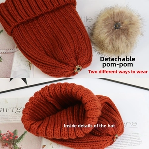 Detail der orangefarbenen Strickmütze mit abnehmbarem Kunstfell-Pompon und Druckknopf