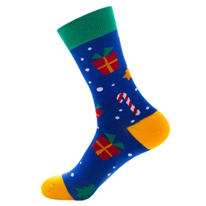 Close-up of blue cotton sock with Christmas gift and candy cane patterns on white background