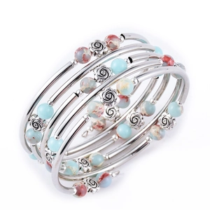 Multi-layer wrap bracelet featuring turquoise beads and silver rose charms on white background