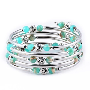 Macro shot of turquoise beaded multi-layer bracelet with vintage silver rose metal details