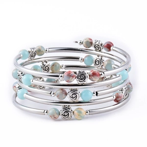 Macro detail of multilayer boho bracelet with turquoise beads and silver rose charms
