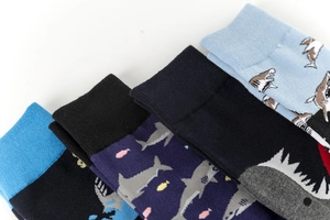 Detailed view of four pairs of shark pattern mid-calf cotton socks in blue and black shades