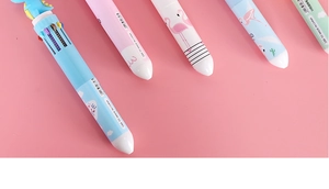Detail of multi-color ballpoint pens with blue dinosaur topper and flamingo patterns