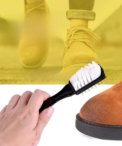 Detail of dual-sided suede shoe brush featuring copper wire bristles and rubber teeth