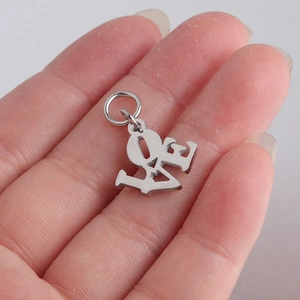 Polished silver stainless steel LOVE hollow pendant held in palm with jump ring