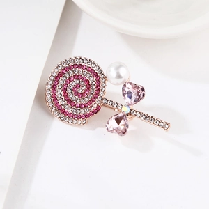 Detail of lollipop brooch with pink rhinestones, pearl accent, and rose gold base