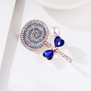 Macro detail of lollipop brooch featuring blue rhinestones and heart-shaped crystals