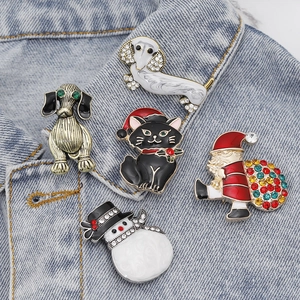 Christmas brooches with snowman, Santa, and pets pinned on a denim jacket collar