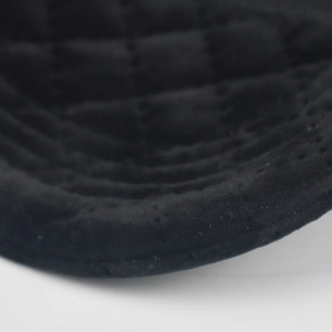 Close-up of black quilted corduroy baseball cap showing reinforced stitching details